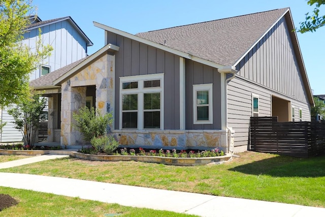 8801 Mina Dr, Austin, TX 78747 - view of front facade with stone siding, roof with shingles, and board and batten siding