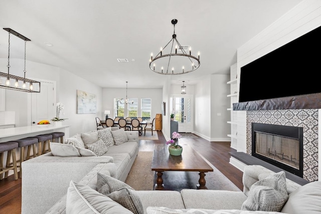 622 Galston Dr, Spicewood, TX 78669 - living room with a chandelier, wood finished floors, and a tile fireplace