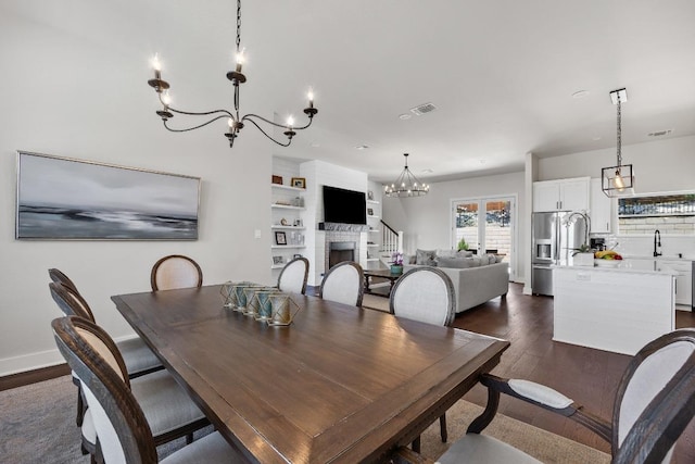 622 Galston Dr, Spicewood, TX 78669 - dining area featuring a chandelier, dark wood-style floors, and a fireplace