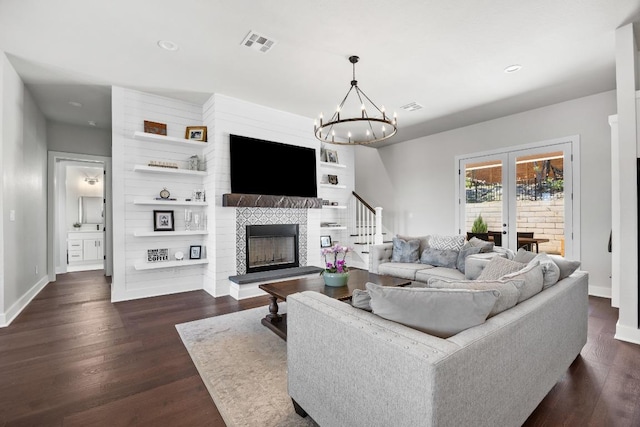 622 Galston Dr, Spicewood, TX 78669 - living area with a fireplace with raised hearth, dark wood finished floors, stairway, a chandelier, and recessed lighting