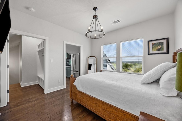 622 Galston Dr, Spicewood, TX 78669 - bedroom with freestanding refrigerator, dark wood finished floors, and a chandelier