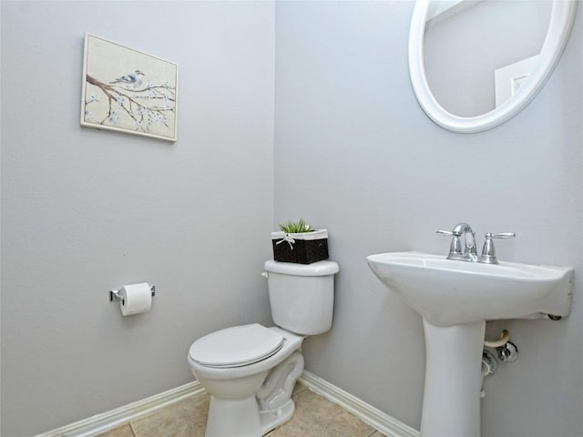 bathroom featuring toilet, baseboards, and tile patterned floors