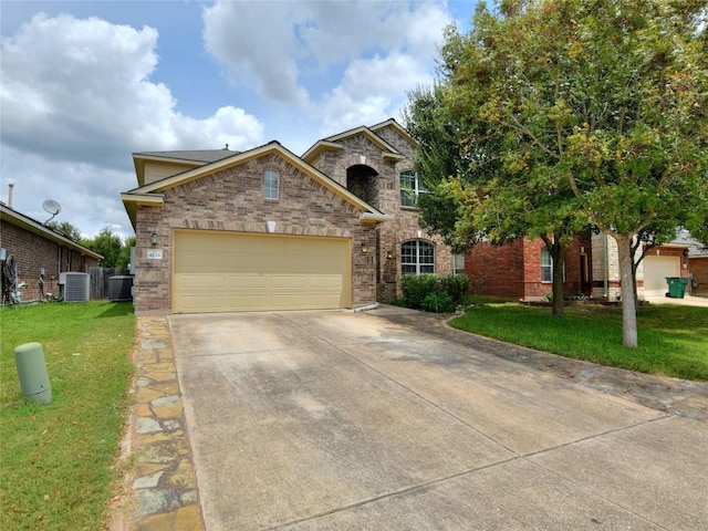 view of front of house with central air condition unit, concrete driveway, brick siding, and a front yard