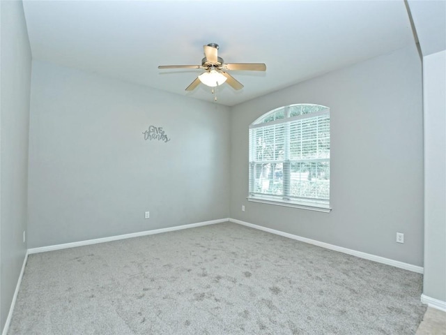 spare room with baseboards, carpet flooring, and ceiling fan
