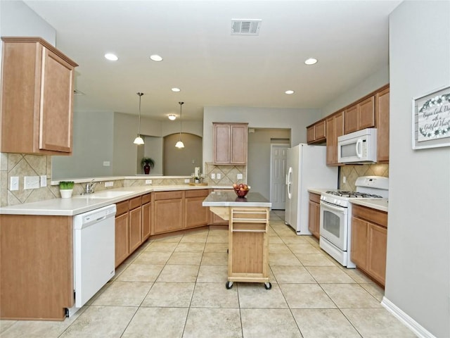 kitchen with a sink, a peninsula, white appliances, recessed lighting, and decorative backsplash