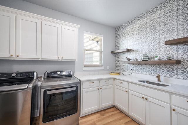 3401 Bandit Ct, Kempner, TX 76539 - laundry room with separate washer and dryer, cabinet space, and light wood-style floors