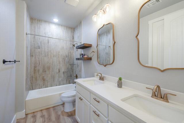 3401 Bandit Ct, Kempner, TX 76539 - bathroom featuring double vanity, shower / bathtub combination, and wood finished floors