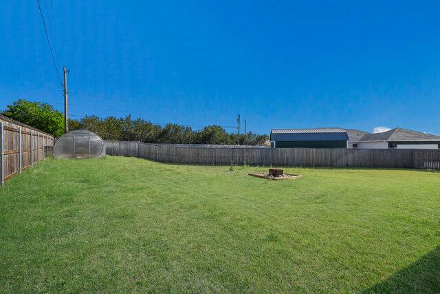 3401 Bandit Ct, Kempner, TX 76539 - fenced backyard featuring a greenhouse and an outbuilding