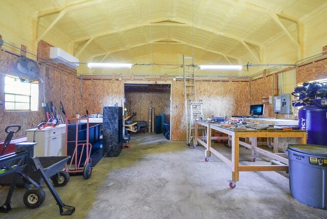 3401 Bandit Ct, Kempner, TX 76539 - misc room featuring a workshop area, electric panel, unfinished concrete floors, a garage, and a wall mounted AC