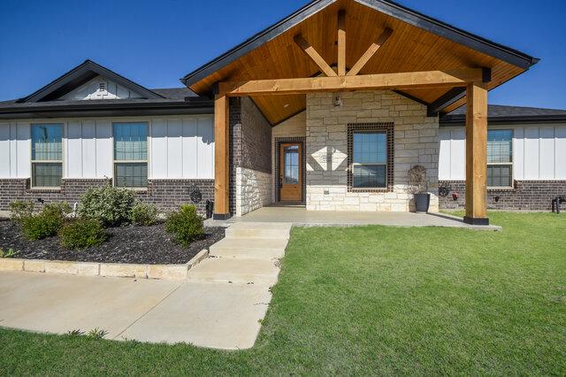 3401 Bandit Ct, Kempner, TX 76539 - view of front of property featuring board and batten siding, a front lawn, brick siding, and stone siding