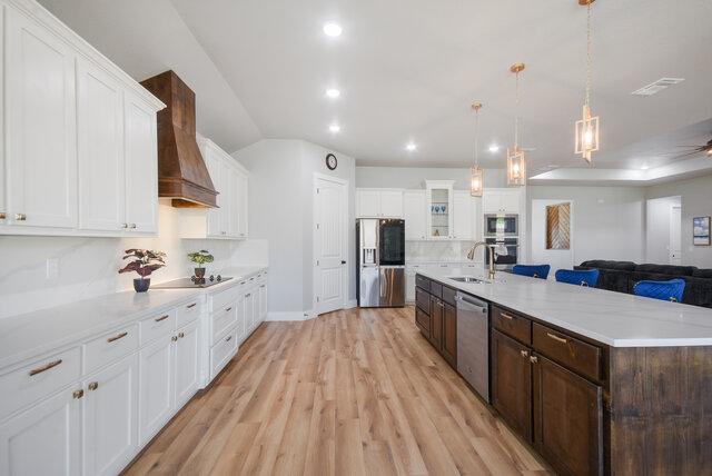 3401 Bandit Ct, Kempner, TX 76539 - kitchen with appliances with stainless steel finishes, light wood-style flooring, white cabinetry, dark brown cabinets, and recessed lighting