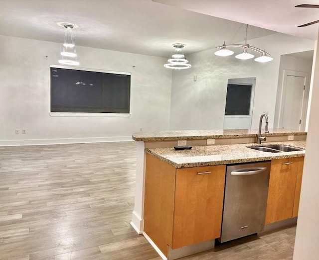 603 Davis St Unit 804, Austin, TX 78701 - kitchen with a sink, brown cabinets, decorative light fixtures, light wood-style floors, and light stone countertops