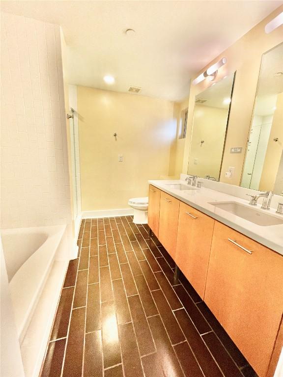 603 Davis St Unit 804, Austin, TX 78701 - bathroom featuring double vanity, toilet, a bath, and a shower