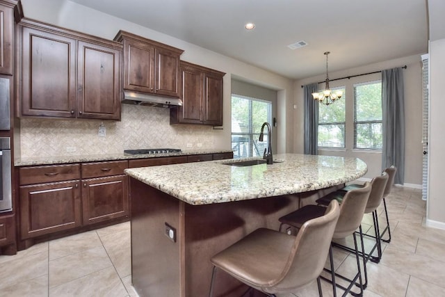 1706 Ambling Trl, Cedar Park, TX 78613 - kitchen featuring a sink, a chandelier, under cabinet range hood, tasteful backsplash, and light tile patterned floors