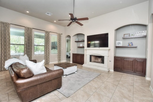 1706 Ambling Trl, Cedar Park, TX 78613 - living area with a ceiling fan, a fireplace with raised hearth, arched walkways, light tile patterned flooring, and recessed lighting