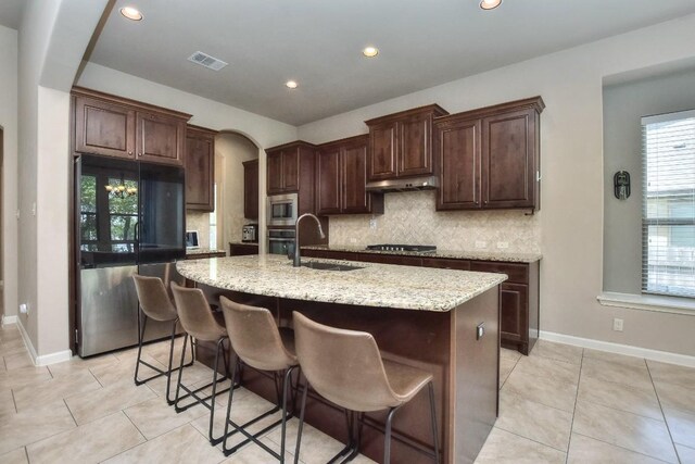 1706 Ambling Trl, Cedar Park, TX 78613 - kitchen with appliances with stainless steel finishes, a sink, tasteful backsplash, an island with sink, and light stone counters