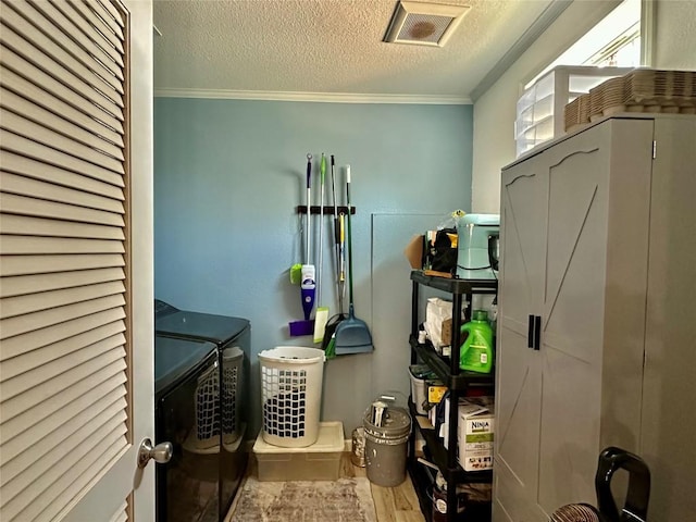 1021 Lewis Ln, Harwood, TX 78632 - washroom featuring a textured ceiling, washer and clothes dryer, crown molding, and wood finished floors