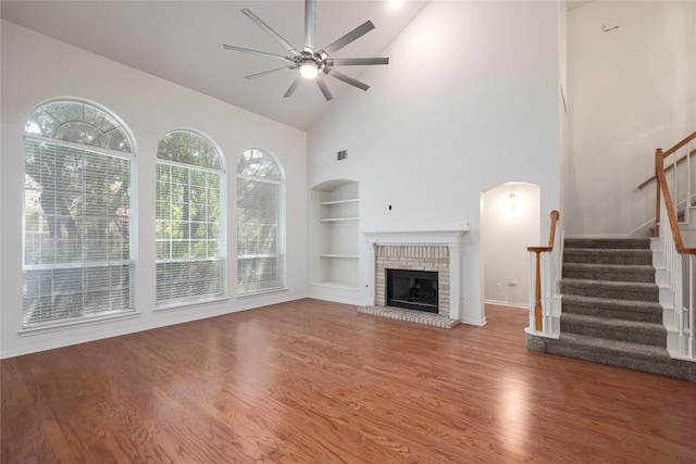 6008 Sierra Leon St, Austin, TX 78759 - unfurnished living room with built in shelves, a ceiling fan, wood finished floors, high vaulted ceiling, and stairs