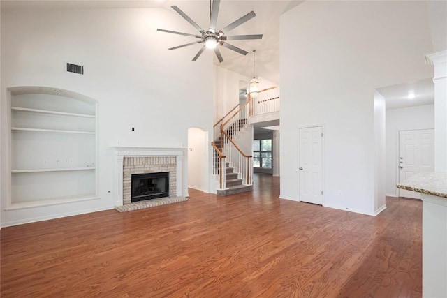 6008 Sierra Leon St, Austin, TX 78759 - unfurnished living room featuring high vaulted ceiling, built in features, ceiling fan, stairs, and wood finished floors