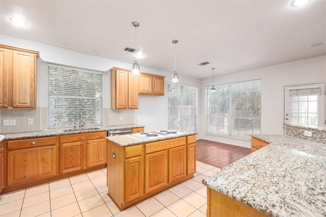 6008 Sierra Leon St, Austin, TX 78759 - kitchen featuring decorative backsplash, healthy amount of natural light, light stone counters, and decorative light fixtures