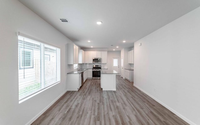 510 Timber Brook Dr, Hutto, TX 78634 - kitchen with light wood finished floors, white cabinets, baseboards, appliances with stainless steel finishes, and visible vents