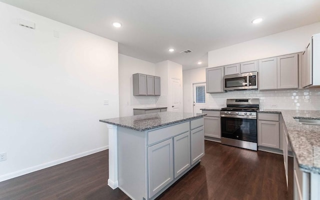 108 Biscayne Dr, Hutto, TX 78634 - kitchen with stainless steel appliances, gray cabinetry, dark wood-style floors, and tasteful backsplash