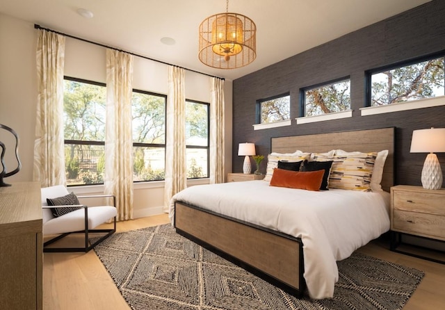 2002 Clearlight Ln, Georgetown, TX 78633 - bedroom with multiple windows, wood finished floors, and a chandelier
