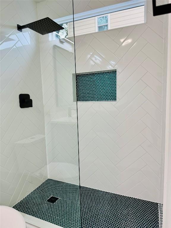 bathroom with toilet and tiled shower