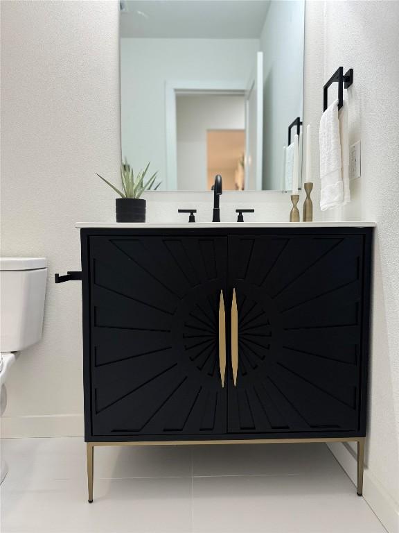bathroom with vanity, baseboards, and toilet
