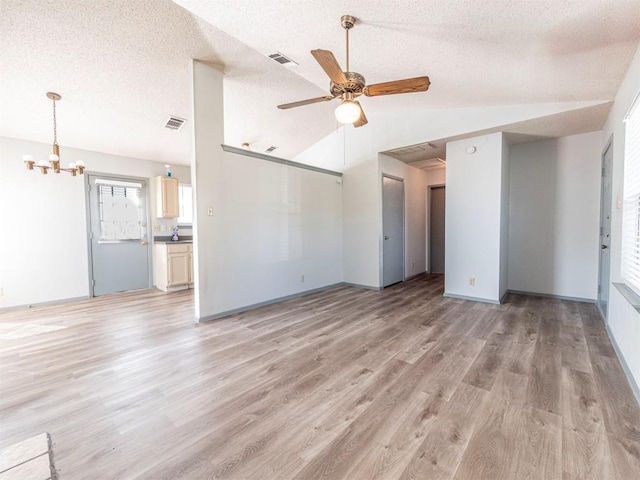 9624 Sugar Hill Dr Unit A & B, Austin, TX 78748 - unfurnished living room featuring vaulted ceiling, a chandelier, a ceiling fan, light wood finished floors, and a textured ceiling