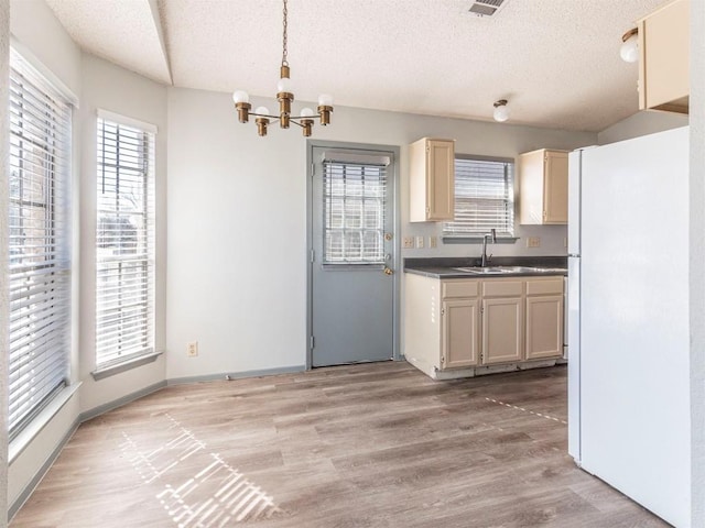 9624 Sugar Hill Dr Unit A & B, Austin, TX 78748 - kitchen featuring freestanding refrigerator, a textured ceiling, a chandelier, light wood-type flooring, and dark countertops