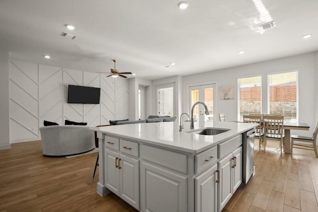 431 Wild Pecan Loop, Buda, TX 78610 - kitchen with wood finished floors, healthy amount of natural light, light countertops, a center island with sink, and recessed lighting