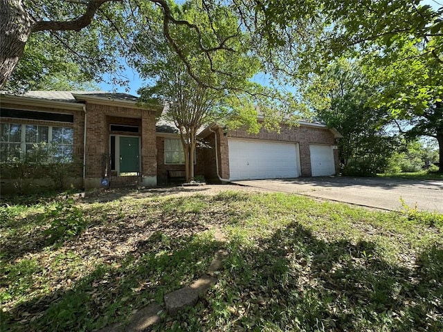view of front of house with a garage, driveway, and brick siding