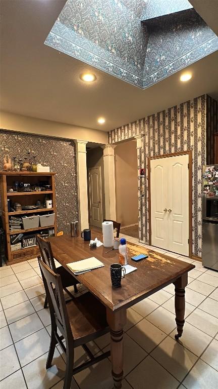 wine area with wallpapered walls, light tile patterned floors, decorative columns, and recessed lighting