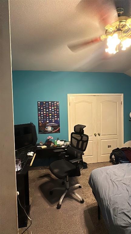 bedroom featuring a textured ceiling, a closet, a ceiling fan, and carpet