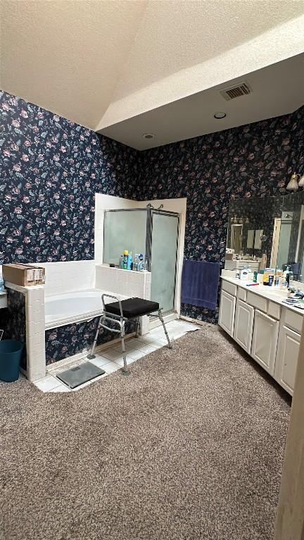bathroom featuring visible vents, a bath, a shower stall, vanity, and wallpapered walls