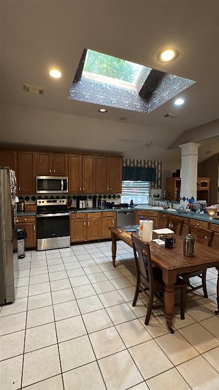 kitchen with tasteful backsplash, visible vents, appliances with stainless steel finishes, dark countertops, and light tile patterned flooring