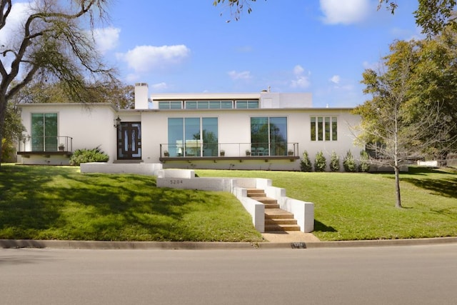 5204 Ridge Oak Dr, Austin, TX 78731 - view of front of property featuring stucco siding, a front yard, and a chimney