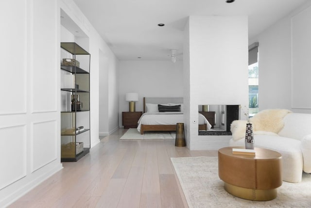 5204 Ridge Oak Dr, Austin, TX 78731 - bedroom featuring a multi sided fireplace, wood finished floors, and recessed lighting