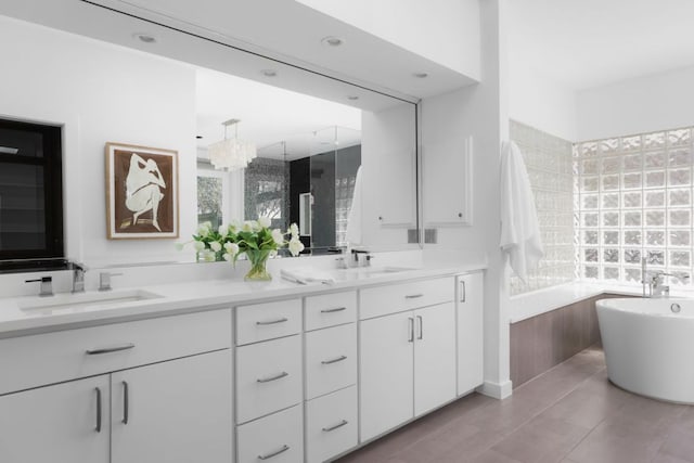 5204 Ridge Oak Dr, Austin, TX 78731 - bathroom featuring double vanity, a freestanding bath, healthy amount of natural light, and a chandelier