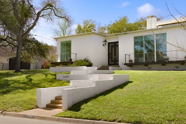 5204 Ridge Oak Dr, Austin, TX 78731 - view of front of house featuring stucco siding, a front lawn, and a chimney