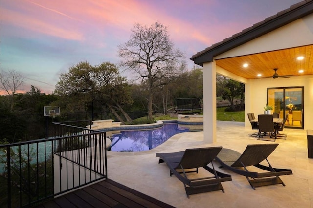 2809 Waterbank Cv, Austin, TX 78746 - pool at dusk featuring ceiling fan, a patio area, a pool with connected hot tub, and outdoor dining area