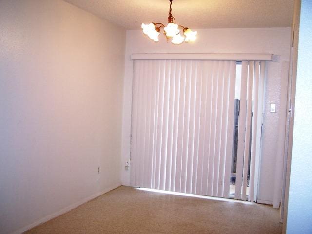 817 Lexington Rd, Elgin, TX 78621 - carpeted spare room featuring a notable chandelier