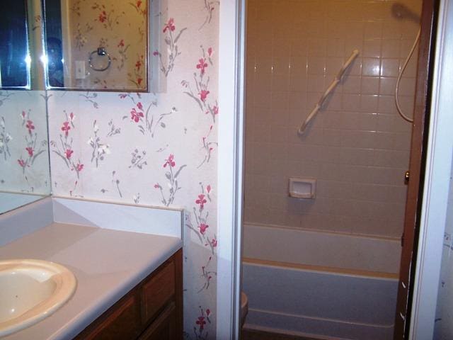 817 Lexington Rd, Elgin, TX 78621 - full bathroom featuring vanity, shower / bathing tub combination, wallpapered walls, and toilet