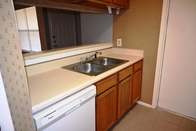 817 Lexington Rd, Elgin, TX 78621 - kitchen with a sink, light countertops, brown cabinetry, and white dishwasher