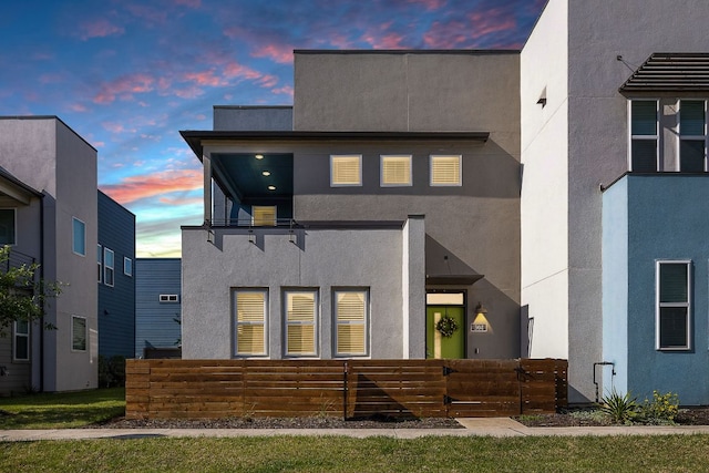 view of front facade featuring fence and stucco siding