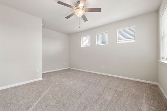 spare room with ceiling fan, carpet floors, and baseboards