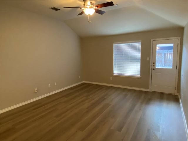 interior space featuring baseboards, a ceiling fan, dark wood-type flooring, visible vents, and lofted ceiling