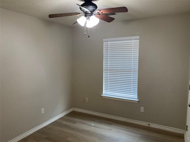 spare room featuring ceiling fan, wood finished floors, and baseboards