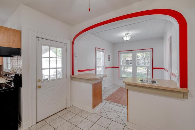 700 S Walnut Ave, Luling, TX 78648 - kitchen featuring black range with electric cooktop, a peninsula, light tile patterned floors, and plenty of natural light